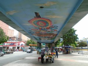 Kunst unter der Hochbahn: die U-Bahn in Medellin fährt auf Stälzen und daher wird der Platz unten genutzt für Kunst und vielfältige Märkte.