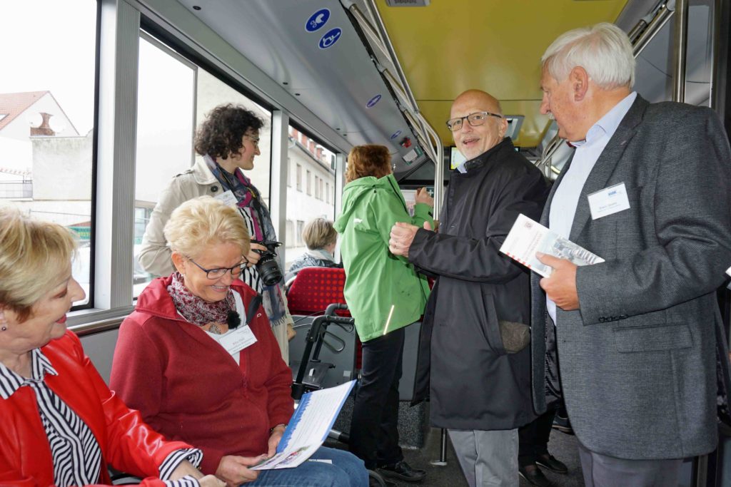 Innenaufnahme eines Busses mit verschiedenen Menschen beim Speeddating für Engagement