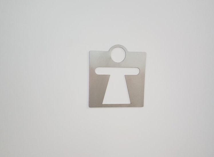 Wenig kontrastreiche Markierung der Toiletten: Die Figur ist aus Edelstahl auf die Tür aufgeklebt. Der Innenbereich ist weiß (durch die Tür).