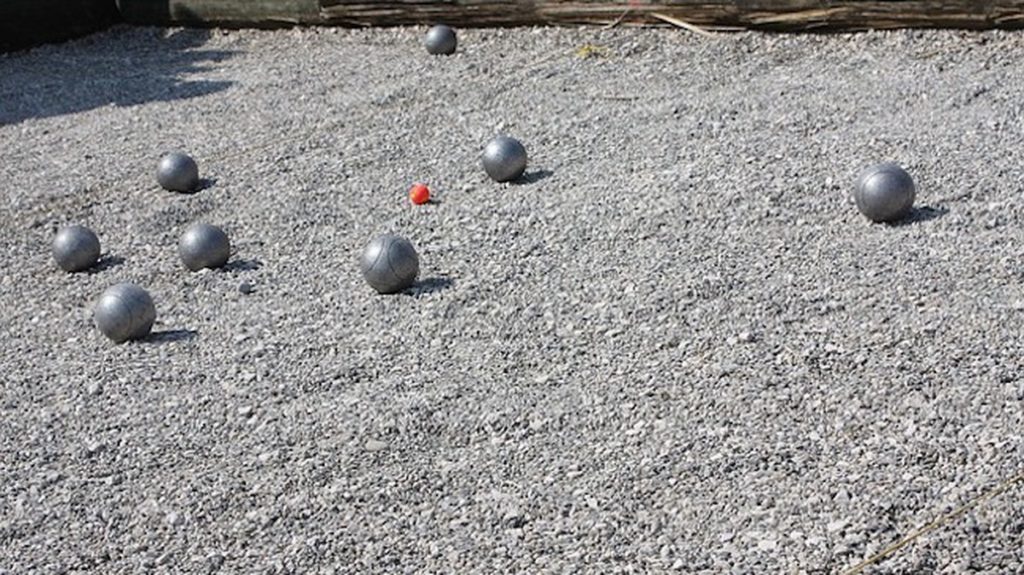 Boule-Spiel im Freien - eine rote kleine Kugel ist umgeben von größeren, silbernen