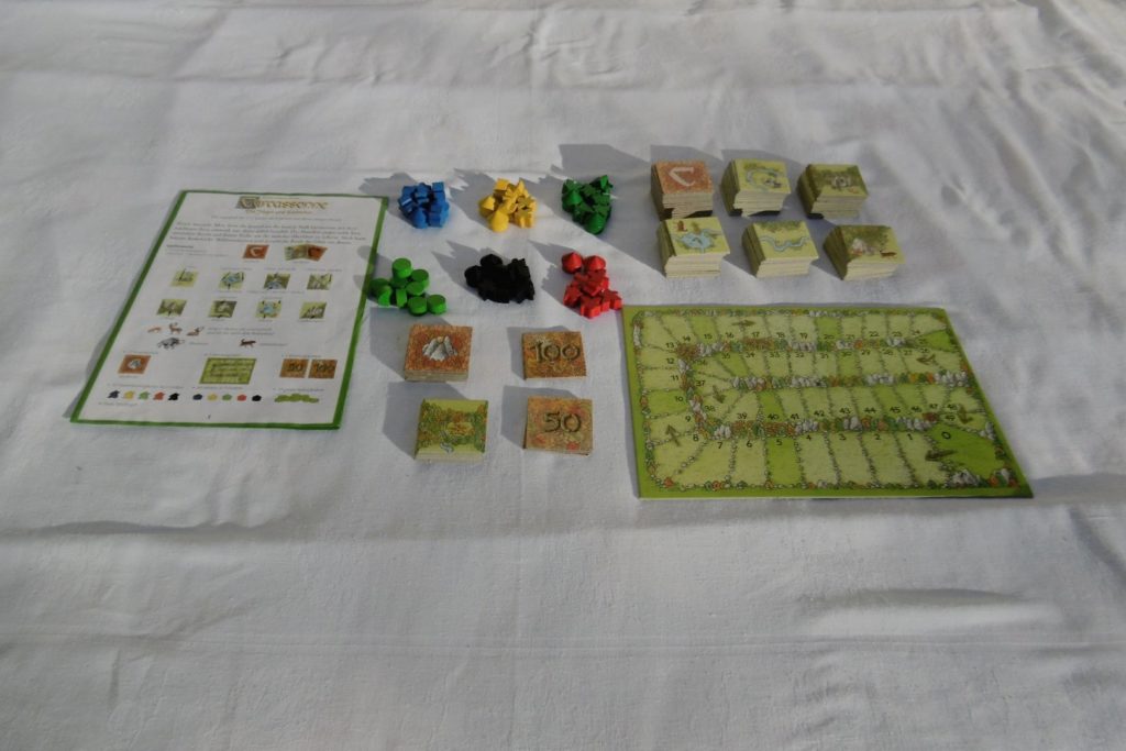 Der Inhalt des Spiels - alle Karten und Figuren / Häuser sind auf dem Tisch ausgelegt