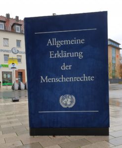 Das Bild zeigt eine Plastik am Rande des Hanauer Freiheitsplatz. Zu sehen ist ein überdimensionales großes Buch mit dem Titel Allgemeine Erklärung der Menschenrechte.