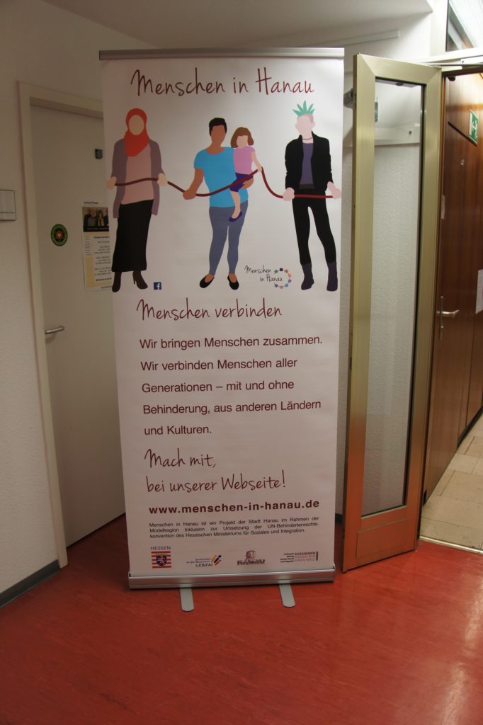 Auf dem Bild zu sehen ist der Roll-Up zum Projekt "Menschen in Hanau", der im Eingang positioniert wurde.