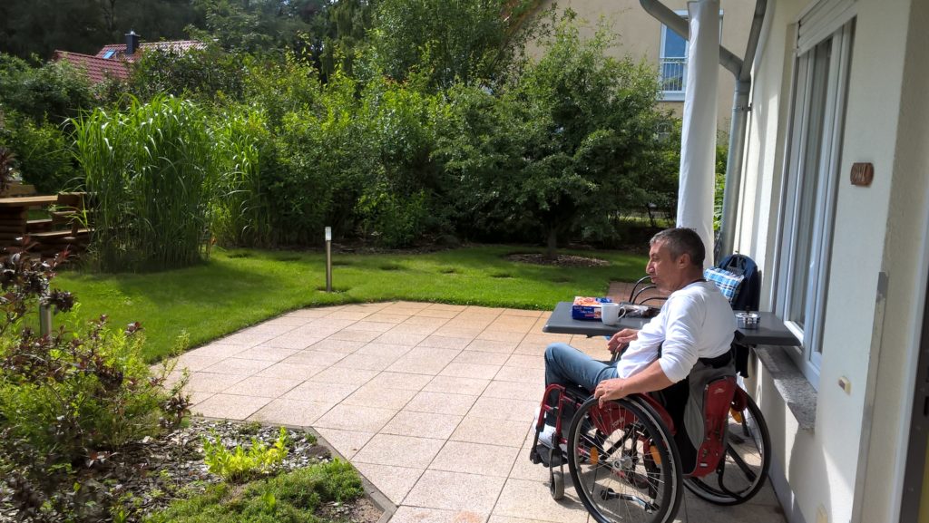 Jürgen im Rollstuhl auf der Terrasse der Ferienwohnung.