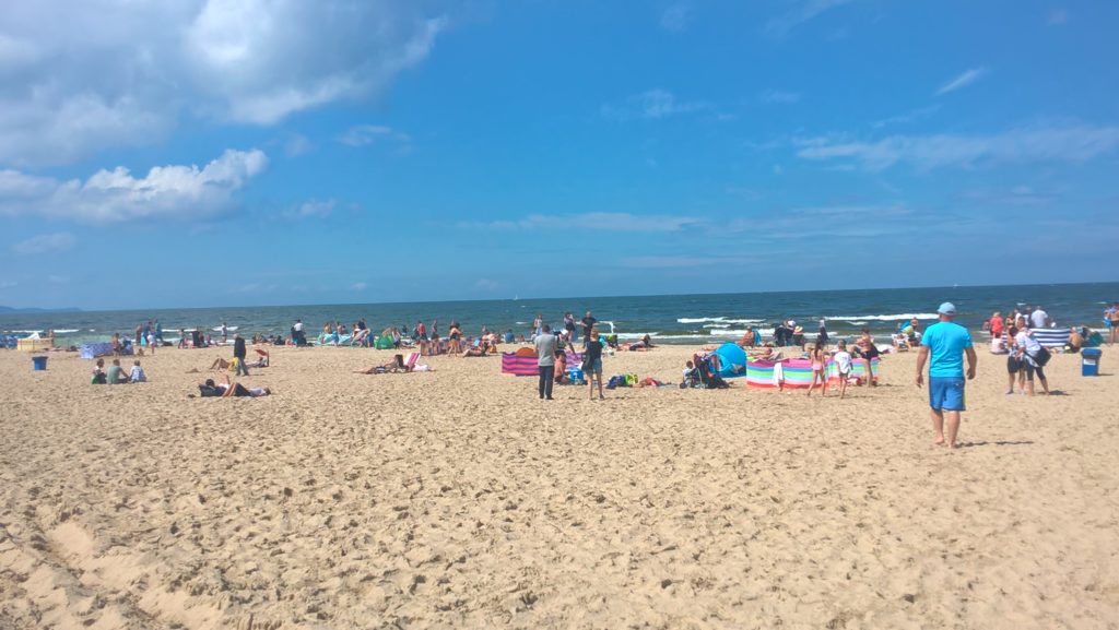 Ostsee-Strand mit blauem Himmel und vielen Menschen