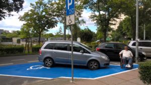 Behindertenparkplatz mit blauen Untergrund - gut sichtbar.