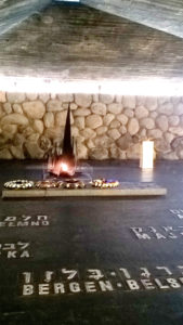 Man sieht auf dem Bild eine brennende Kerze auf dem Boden der Gedenkstätte Yad Vashem