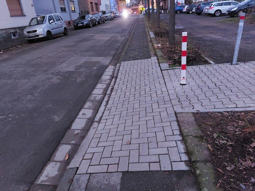 Ein neugepflasterter und abgesenkter Bürgersteig verbindet die Autostraße mit dem Zuweg zum Bahnhsteig.