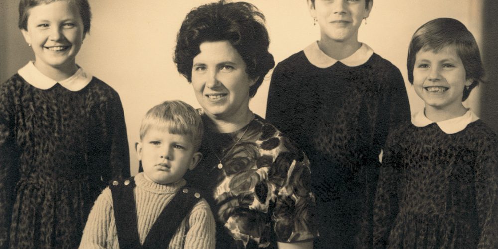 Eine Familie in den 60er Jahren - das Bild ist schwarz weiß und zeigt eine Mutter mit ihren vier Kindern.