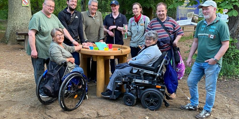 Das Checker-Team steht zu einem Gruppenfoto um einen runden Tisch im Wildpark Fasanerie