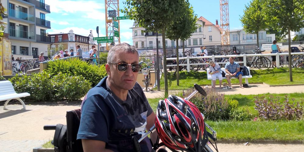 Jürgen mit Handbike mit Blick nach rechts und Fahrrad-Helm